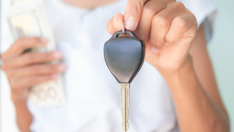 lady holding her car keys and money